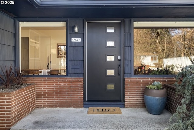 view of exterior entry featuring brick siding