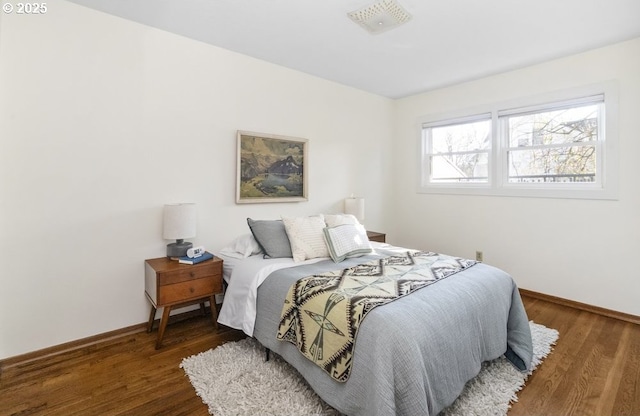 bedroom with baseboards and wood finished floors