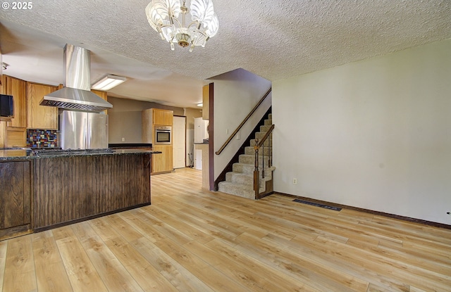 8400 Cason Rd, Gladstone, OR 97027 - kitchen featuring stainless steel appliances, light wood-style floors, a chandelier, backsplash, and island exhaust hood