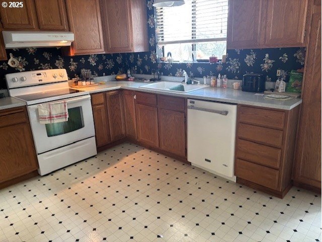 2640 Virginia Ave, North Bend, OR 97459 - kitchen with white appliances, under cabinet range hood, a sink, light floors, and light countertops