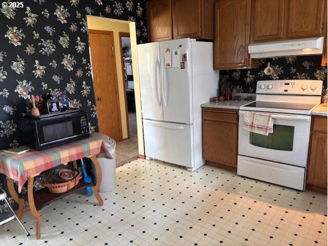 2640 Virginia Ave, North Bend, OR 97459 - kitchen with white appliances, under cabinet range hood, wallpapered walls, light flooring, and light countertops