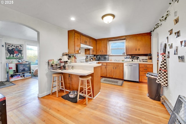 1648 Augusta St, Eugene, OR 97403 - kitchen with dishwasher, arched walkways, under cabinet range hood, light countertops, and a peninsula