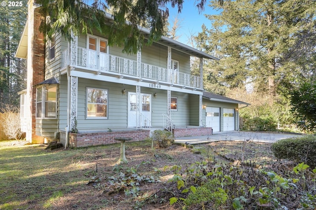 view of front property with driveway and a balcony