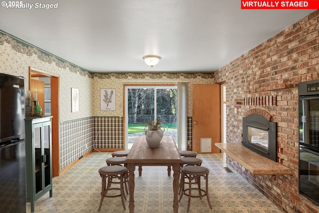 dining area with wallpapered walls and a fireplace