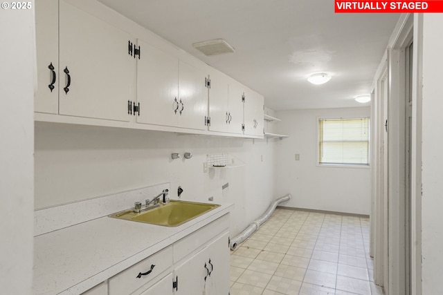 laundry room with visible vents, cabinet space, washer hookup, and a sink