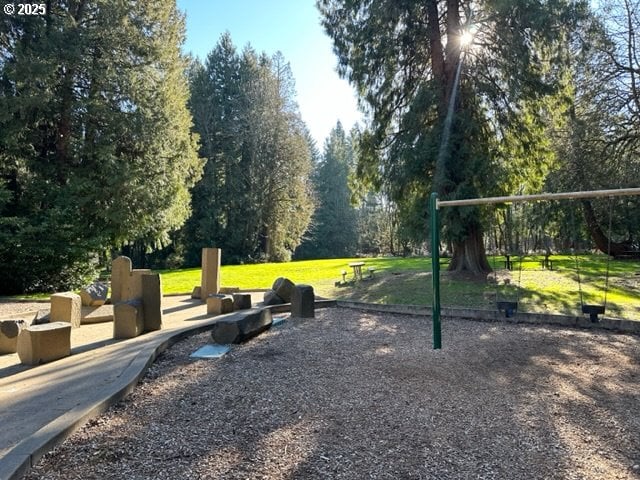 view of home's community featuring playground community and a yard