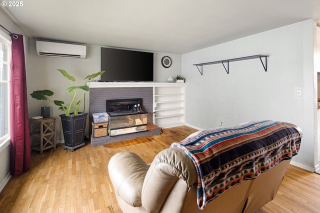 3426 Royal Ave, Eugene, OR 97402 - living room with a wall mounted AC, wood finished floors, baseboards, and a fireplace