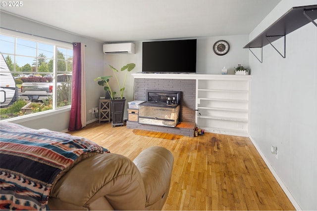 3426 Royal Ave, Eugene, OR 97402 - living area with a wall mounted air conditioner, wood finished floors, baseboards, and a fireplace