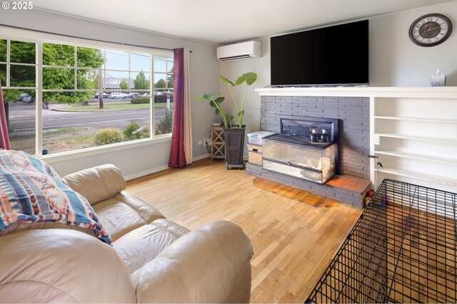 3426 Royal Ave, Eugene, OR 97402 - living room with a wall unit AC, wood finished floors, a brick fireplace, and baseboards