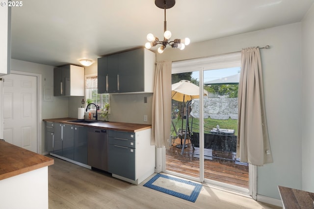 3426 Royal Ave, Eugene, OR 97402 - kitchen with butcher block countertops, stainless steel dishwasher, a sink, light wood-style flooring, and a chandelier