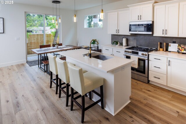 19386 Juniper Ct, Oregon City, OR 97045 - kitchen featuring a sink, light wood finished floors, appliances with stainless steel finishes, and light countertops