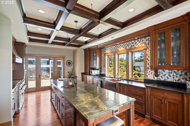 280 Fall Creek Dr, Oceanside, OR 97134 - kitchen featuring dark countertops, a center island, french doors, dark wood-style flooring, and a sink