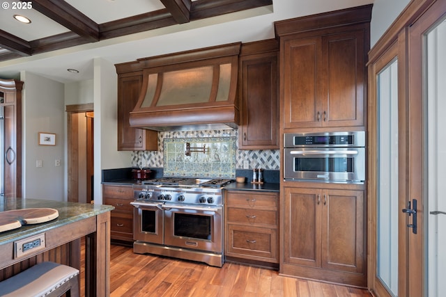 280 Fall Creek Dr, Oceanside, OR 97134 - kitchen with stainless steel appliances, dark countertops, decorative backsplash, beamed ceiling, and light wood finished floors