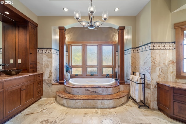 280 Fall Creek Dr, Oceanside, OR 97134 - full bathroom featuring tile walls, vanity, decorative columns, a garden tub, and a wainscoted wall