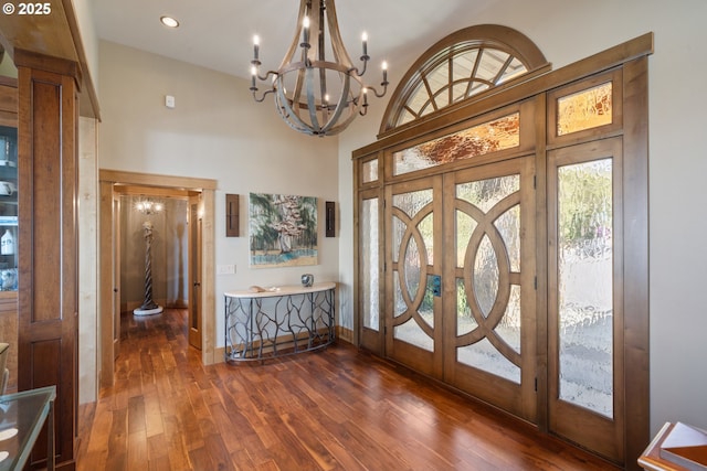 280 Fall Creek Dr, Oceanside, OR 97134 - foyer entrance with french doors, dark wood-style flooring, a high ceiling, a chandelier, and baseboards