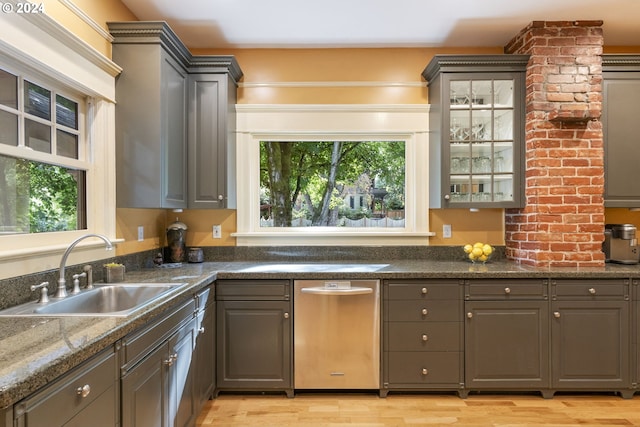 kitchen with light wood-type flooring, dark stone countertops, gray cabinetry, and sink