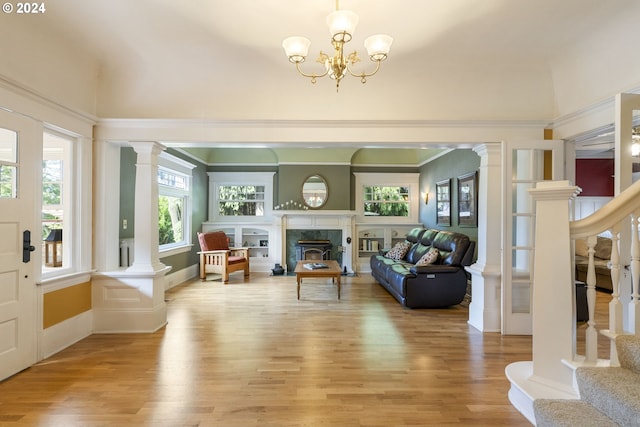 sunroom featuring a high end fireplace and a chandelier