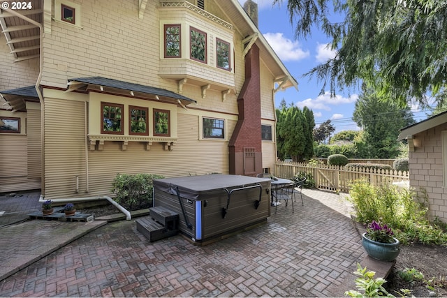 back of house featuring a hot tub and a patio