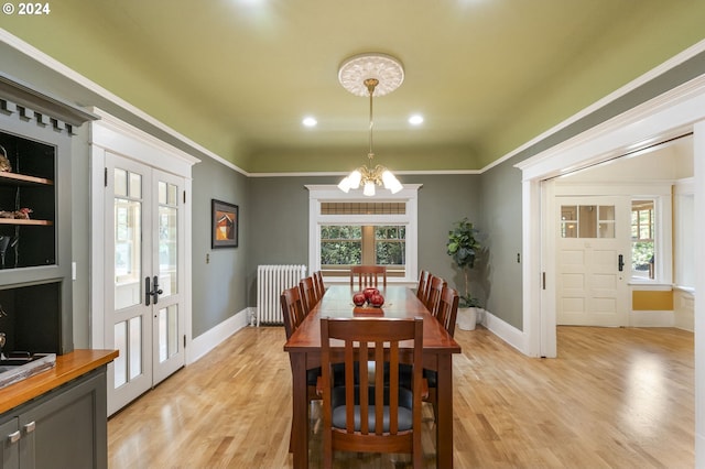 dining space featuring an inviting chandelier, french doors, radiator, and a healthy amount of sunlight