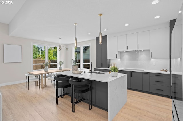 6803 NW 24th Ct, Vancouver, WA 98665 - kitchen with gray cabinetry, cooktop, recessed lighting, a center island with sink, and light wood-style flooring