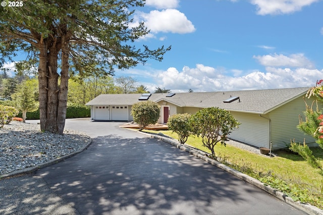 32890 Hillside Acres Rd, Gold Beach, OR 97444 - ranch-style home featuring a garage, aphalt driveway, roof mounted solar panels, and roof with shingles