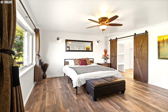 32890 Hillside Acres Rd, Gold Beach, OR 97444 - bedroom with a barn door, ceiling fan, crown molding, baseboards, and wood finished floors