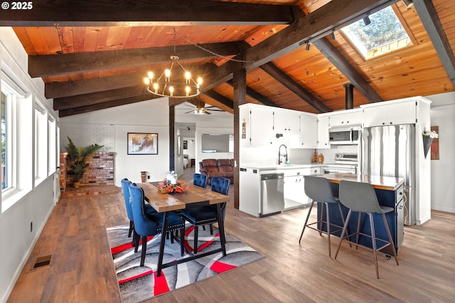 32890 Hillside Acres Rd, Gold Beach, OR 97444 - dining room with vaulted ceiling with skylight, brick wall, light wood-type flooring, visible vents, and wood ceiling