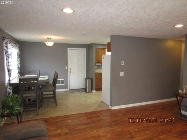 interior space featuring light hardwood / wood-style flooring and a textured ceiling