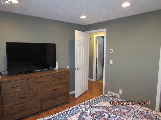 bedroom with wood-type flooring and a textured ceiling