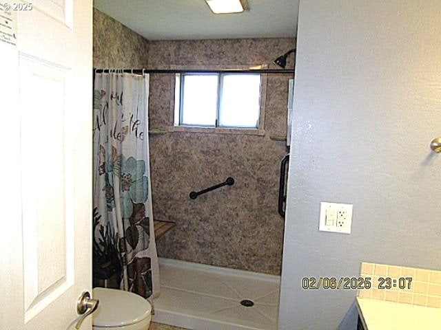 bathroom featuring toilet and a shower with shower curtain