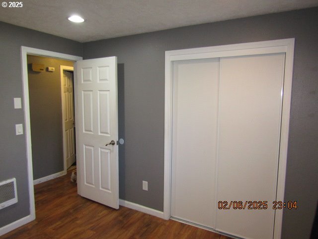 unfurnished bedroom featuring dark wood-type flooring and a closet