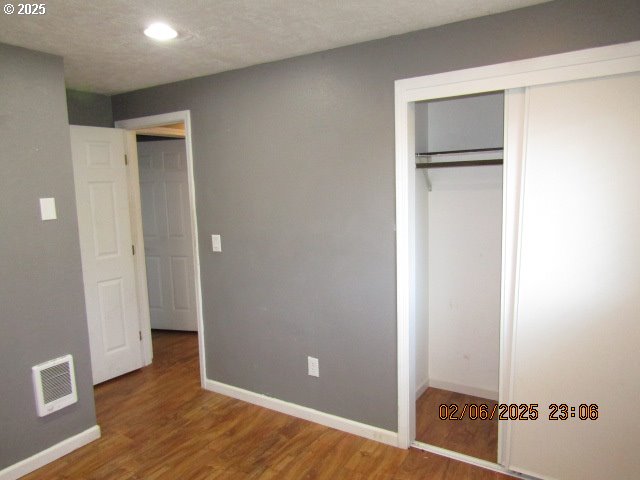 unfurnished bedroom featuring hardwood / wood-style flooring and a closet