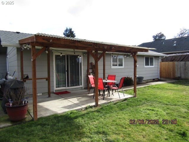 rear view of property featuring a lawn and a patio