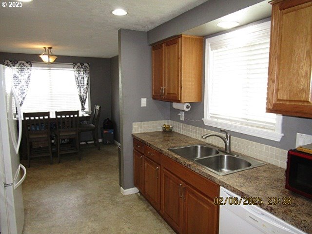 kitchen featuring sink, white appliances, and decorative backsplash