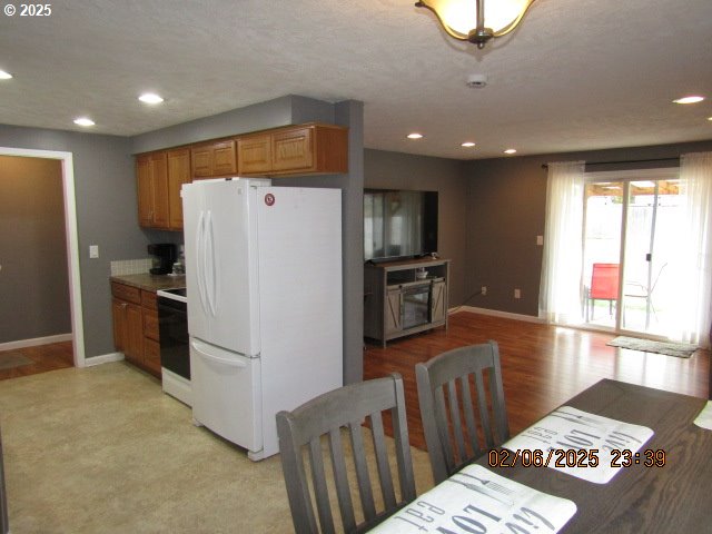 kitchen featuring white refrigerator, range, and light hardwood / wood-style flooring