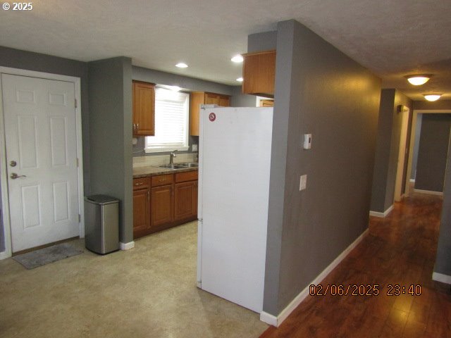 kitchen featuring sink, light hardwood / wood-style floors, and white fridge