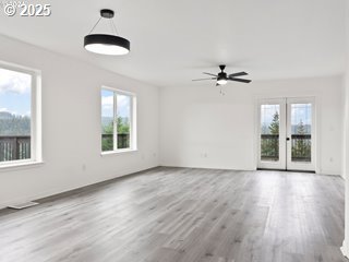 unfurnished living room with ceiling fan, light wood-type flooring, and french doors