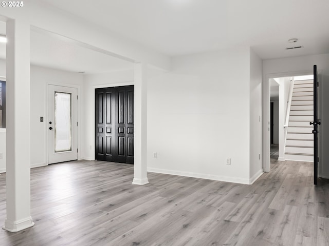 foyer entrance featuring decorative columns and light hardwood / wood-style floors