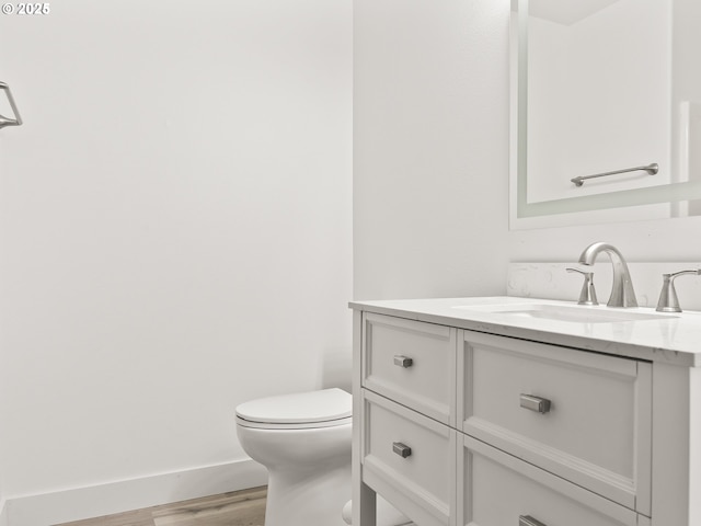 bathroom featuring vanity, toilet, and hardwood / wood-style floors