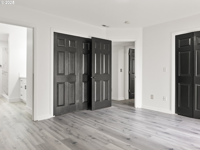 unfurnished bedroom with light hardwood / wood-style flooring and a closet