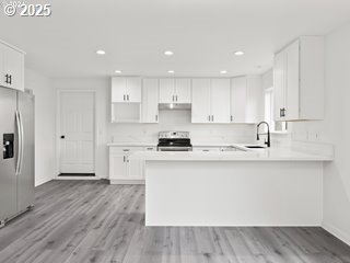 kitchen featuring white cabinetry, appliances with stainless steel finishes, light hardwood / wood-style floors, and kitchen peninsula