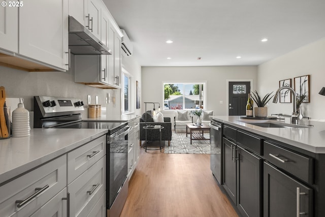4221 Hudson Ave, Salem, OR 97301 - kitchen featuring appliances with stainless steel finishes, under cabinet range hood, recessed lighting, light wood-style floors, and light countertops