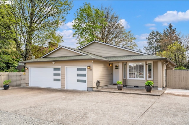 single story home with fence, a shingled roof, and concrete driveway