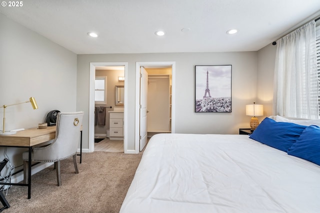 bedroom with ensuite bathroom, baseboards, carpet, a walk in closet, and recessed lighting