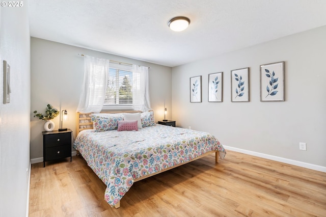 bedroom featuring wood finished floors and baseboards