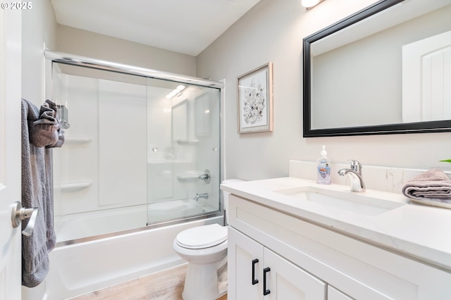 full bathroom with combined bath / shower with glass door, toilet, vanity, and wood finished floors