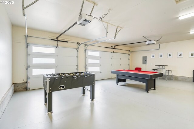 playroom with a healthy amount of sunlight, a garage, electric panel, and concrete floors