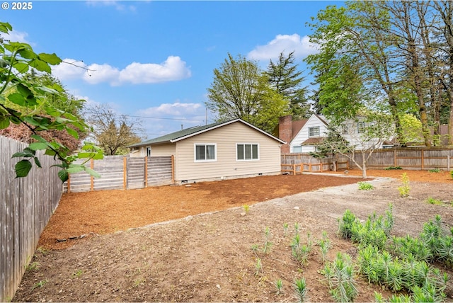 back of house with crawl space and a fenced backyard