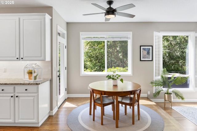 dining room with light wood-type flooring, baseboards, and ceiling fan