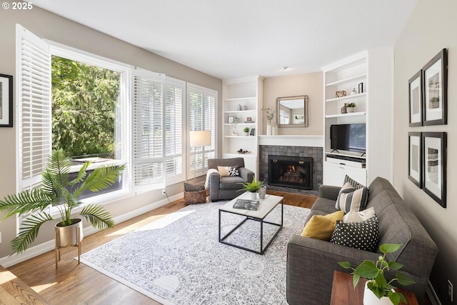 living area featuring plenty of natural light, a fireplace, and wood finished floors